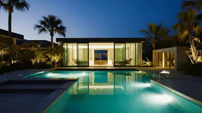 Modern Luxury Villa With Illuminated Swimming Pool At Dusk