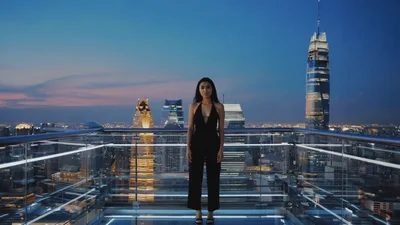 Woman Standing On Glass Observation Deck At Sunset