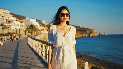 Young Woman Walking Along A Coastal Boardwalk At Sunset