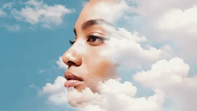 Double Exposure Portrait Of A Woman With Clouds