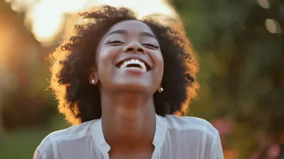 Happy Young Black Woman Laughing Outdoors At Sunset