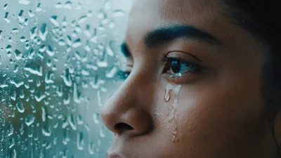 Sad Young Woman Crying By Rainy Window