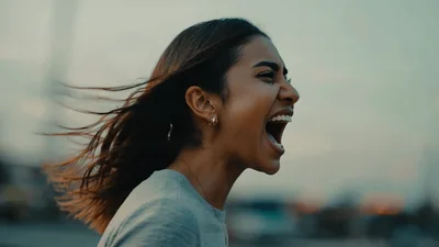 Young Woman Screaming Outdoors At Sunset