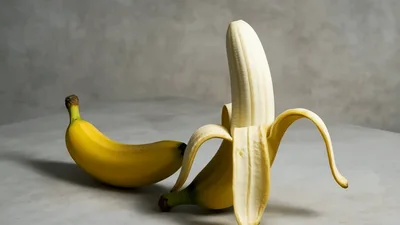 Two Bananas Rotating On A Grey Surface