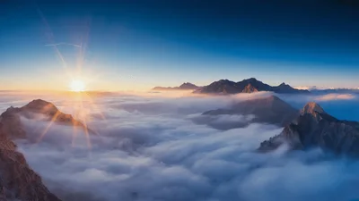 Sunrise Over Mountain Peaks Above A Sea Of Clouds