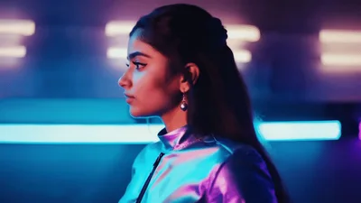 Young Woman Looking Away In Neon Lit Studio
