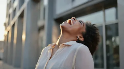 Happy Young Woman Laughing Outdoors In City