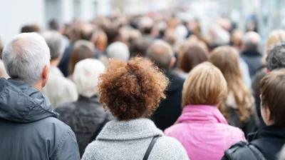 Crowd Of People Walking Down A City Street