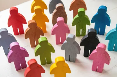 Colorful Wooden Human Figurines Arranged On White Surface