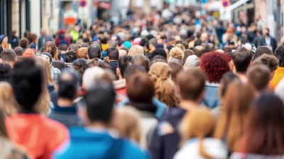 Crowd Of People Walking Down A Busy City Street