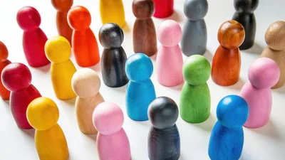 Colorful Wooden Peg People Figurines Arranged On White Surface
