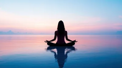 Woman Meditating In Lotus Pose At Sunset
