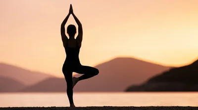 Woman Practicing Tree Pose Yoga At Sunset