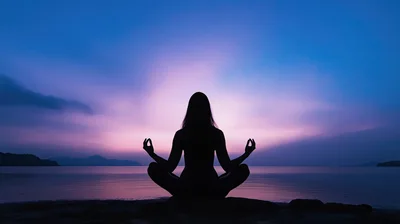 Silhouette of Woman Meditating on Beach at Sunset