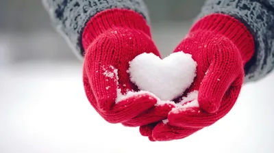 Person Holding A Snow Heart In Red Mittens