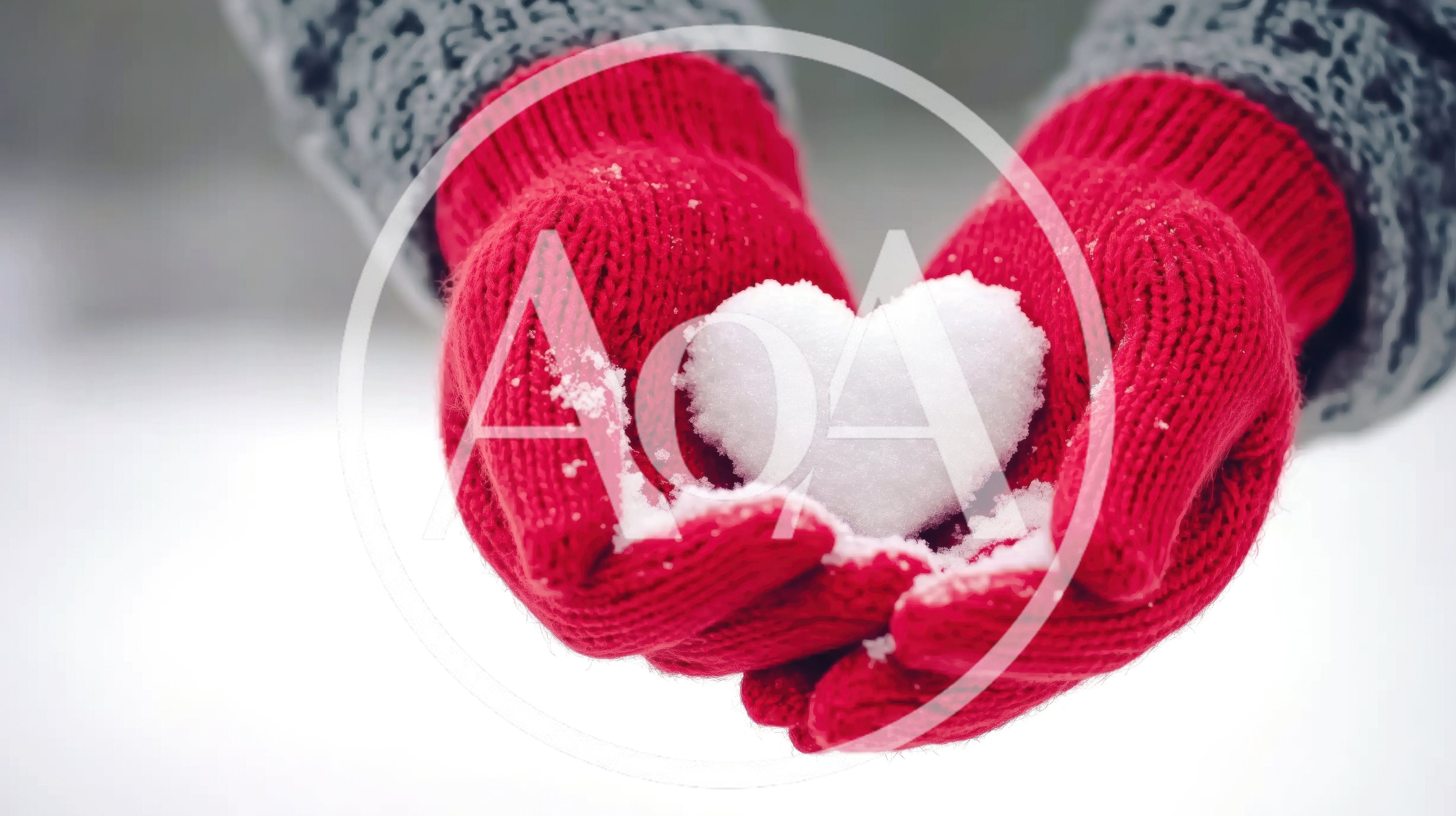 Person Holding A Snow Heart In Red Mittens