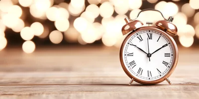 Vintage Alarm Clock on Wooden Table with Bokeh Lights