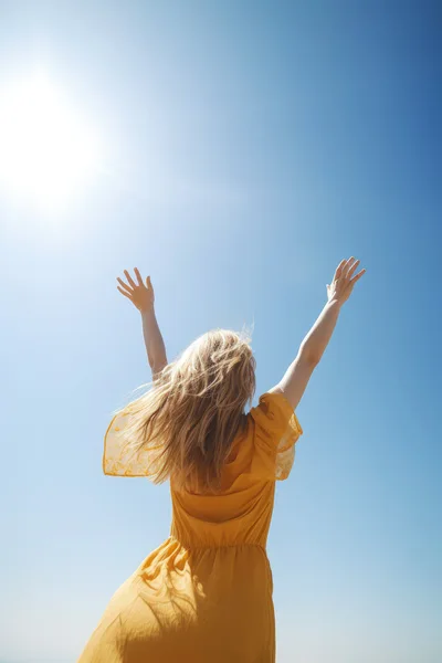 Woman In Yellow Dress Reaching Towards The Sun