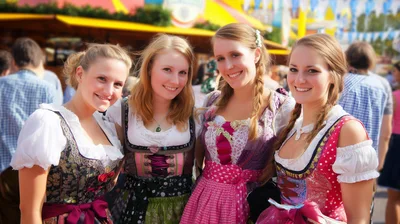 Four Young Women Wearing Traditional Dirndl Dresses