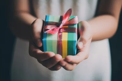 Person Holding A Small Gift Box With Ribbon