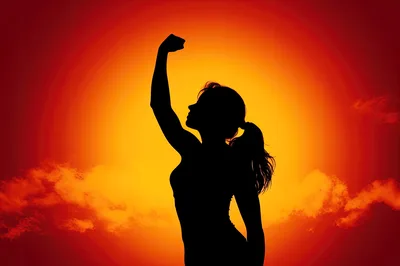 Silhouette Of A Woman Flexing Her Arm At Sunset