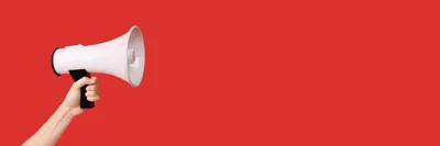 Hand Holding A White Megaphone On Red Background