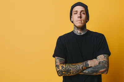 Young Man With Tattoos And Beanie Posing