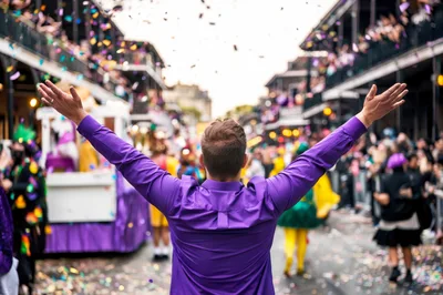 Man Celebrating With Arms Raised At Mardi Gras Parade