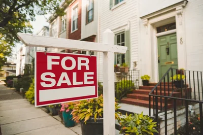 For Sale Real Estate Sign In Front Of Townhouse