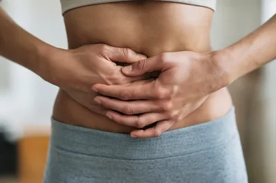 Woman Holding Her Stomach Due To Abdominal Pain