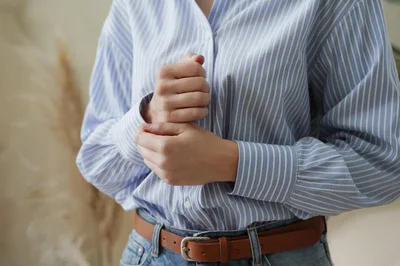 Woman Adjusting Her Striped Button Down Shirt Cuffs