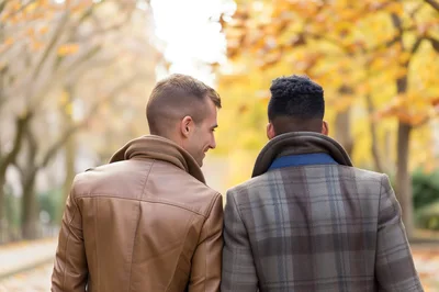 Two Men Walking Together In An Autumn Park