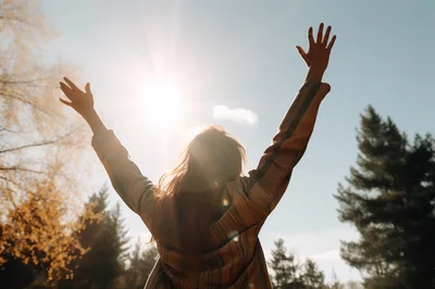 Woman Standing With Arms Raised Towards The Sun