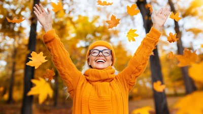 Happy Woman Celebrating Autumn With Falling Leaves