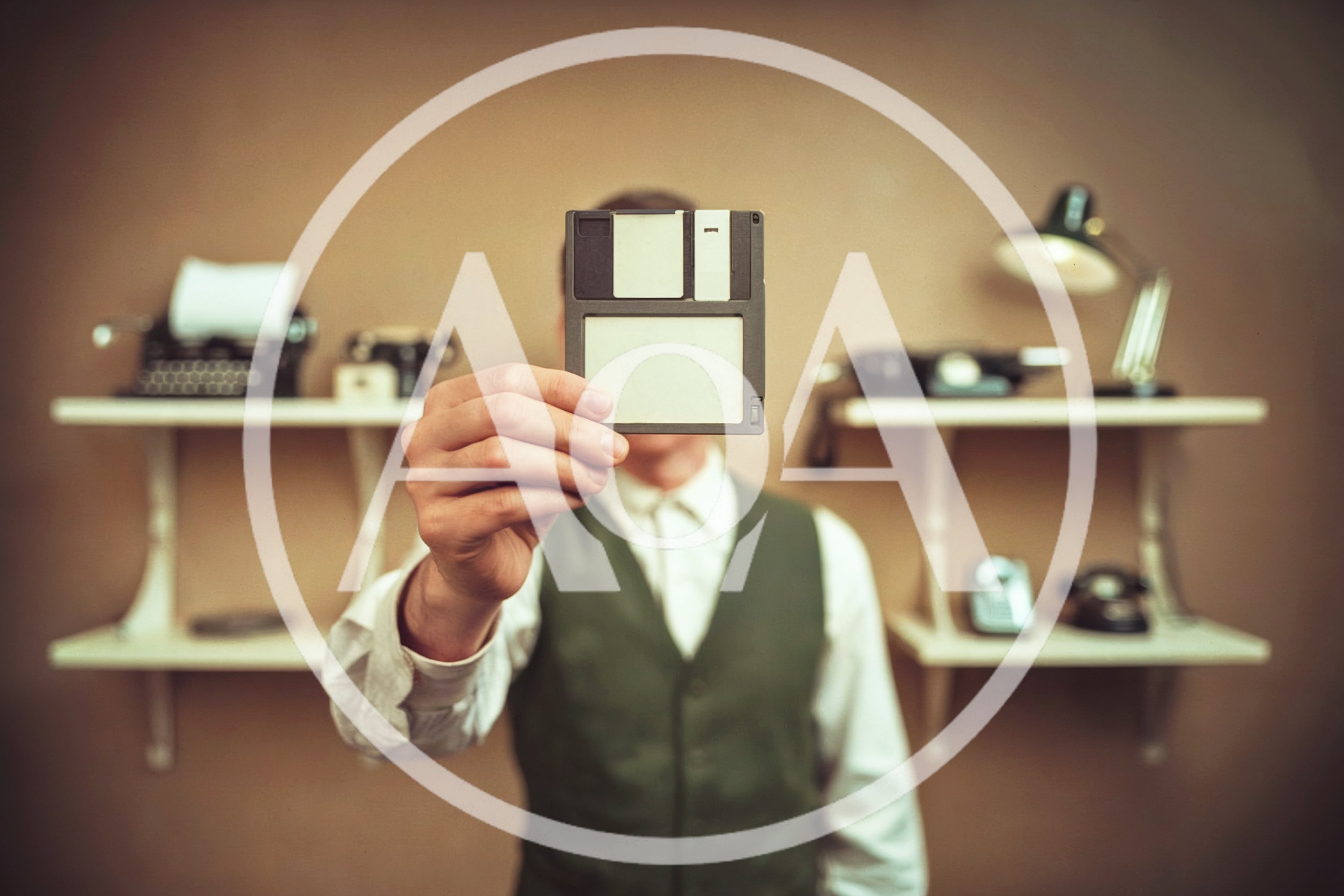 Man Holding Vintage Floppy Disk Over Face