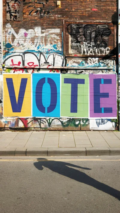 Vote Signage On Graffiti Covered Brick Wall