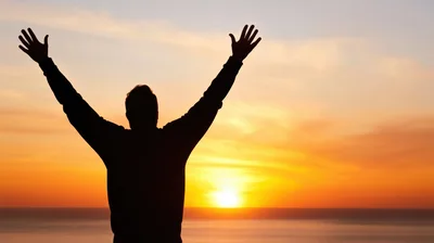 Silhouette Of A Man Celebrating At Sunset