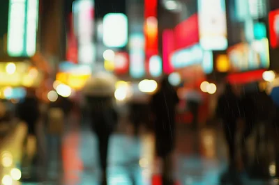 Blurred Pedestrians Walking Through Rainy City Night