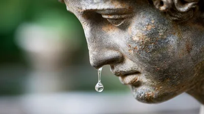 Water Droplet Falling From Stone Statue Nose