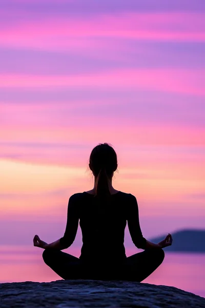 Woman Meditating In Lotus Pose At Sunset