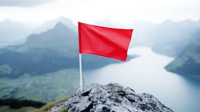 Red Flag Planted On A Rocky Mountain Peak
