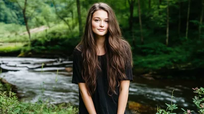 Young Woman Standing By A Forest Stream