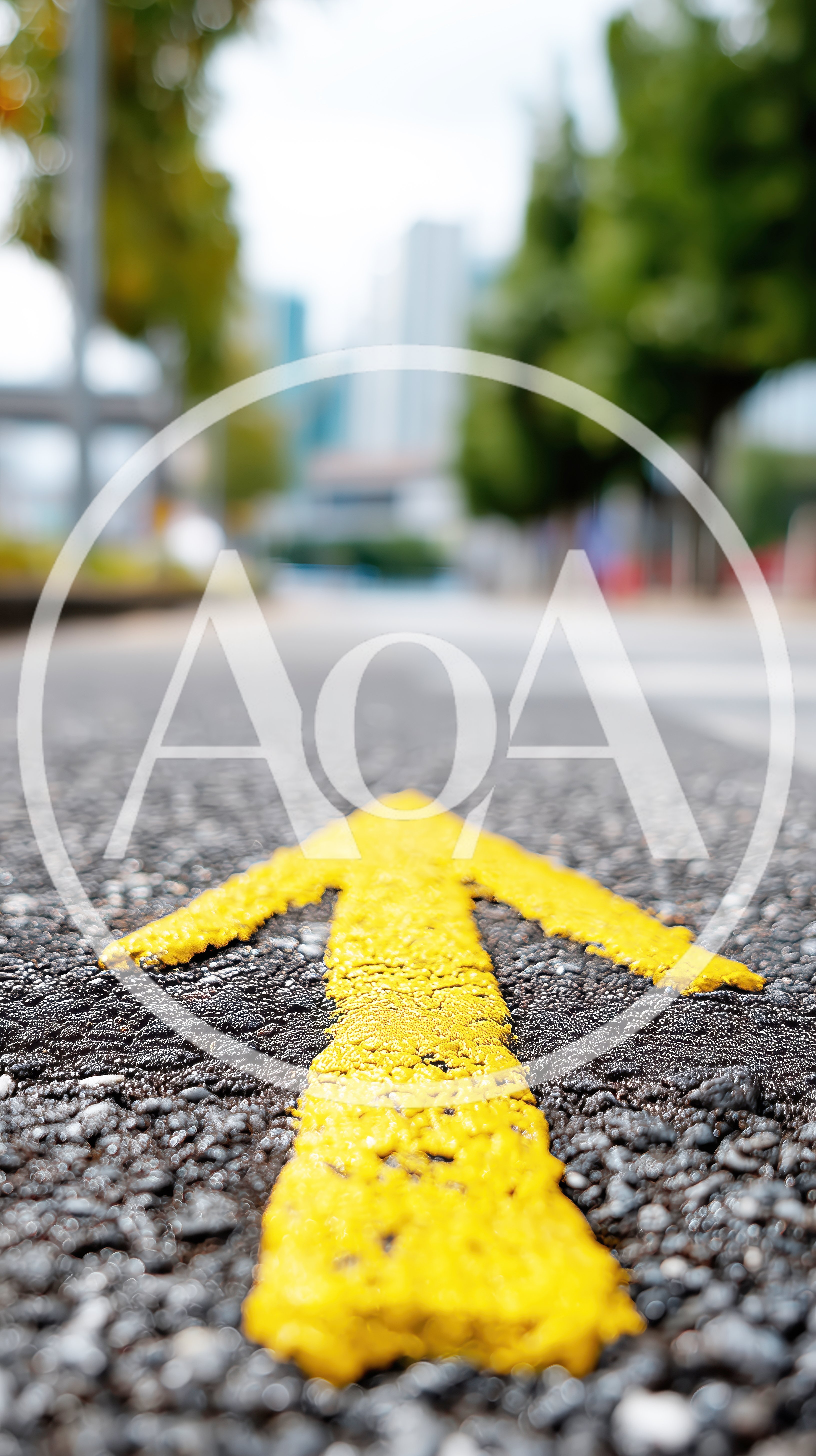 Yellow Painted Directional Arrow On Asphalt Road