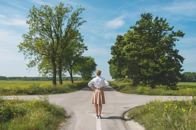 Woman Standing At A Crossroads In The Countryside