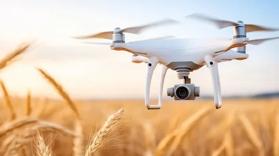 White Quadcopter Drone Flying Over Golden Wheat Field