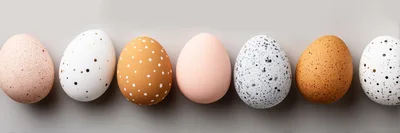 Seven Decorative Easter Eggs Lined Up On Gray Background