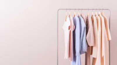 Pastel Clothing Items Hanging On A Minimalist Rack