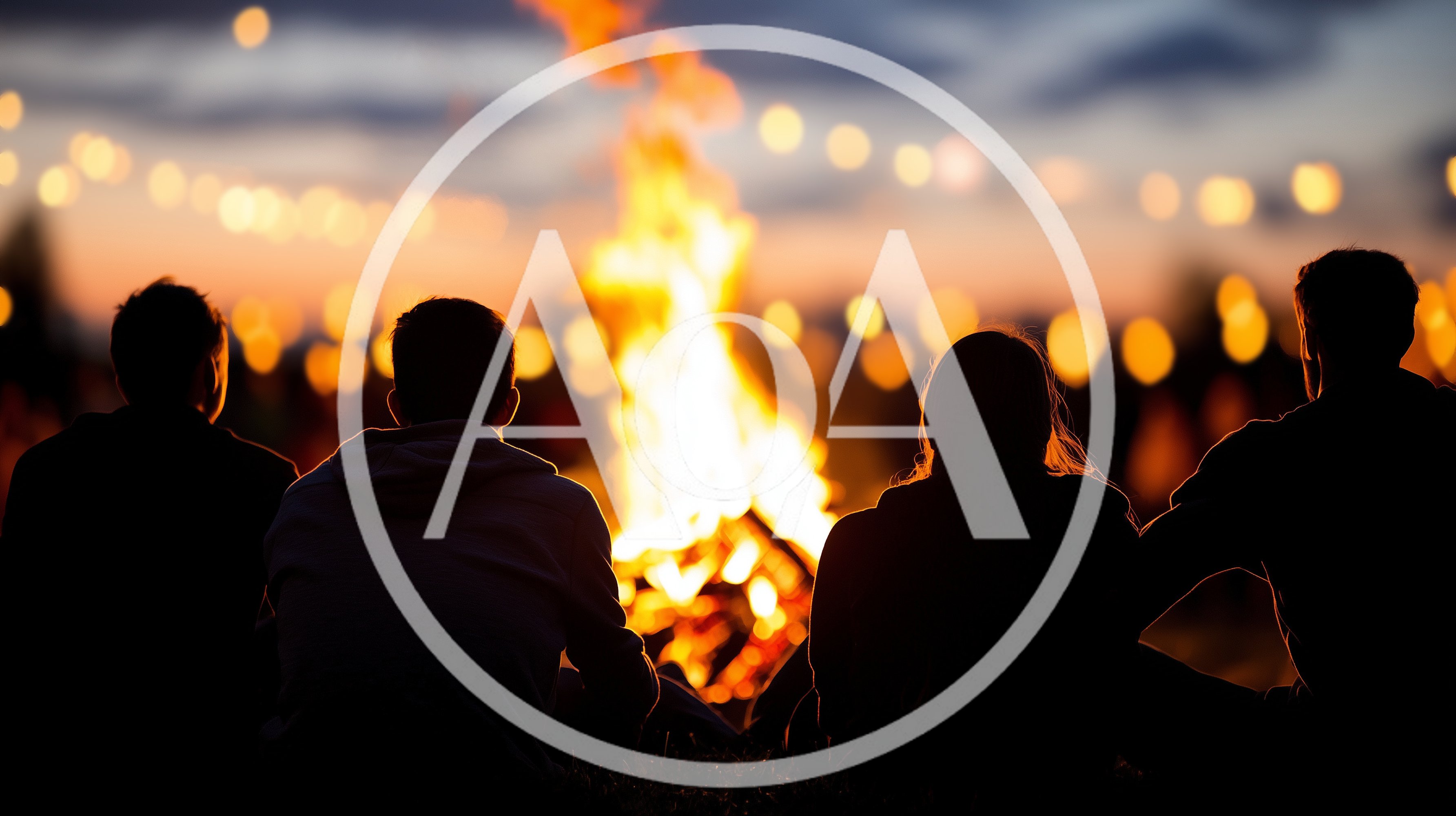 Friends Sitting Around A Bonfire At Sunset