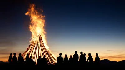 Group Of People Sitting Around A Large Bonfire
