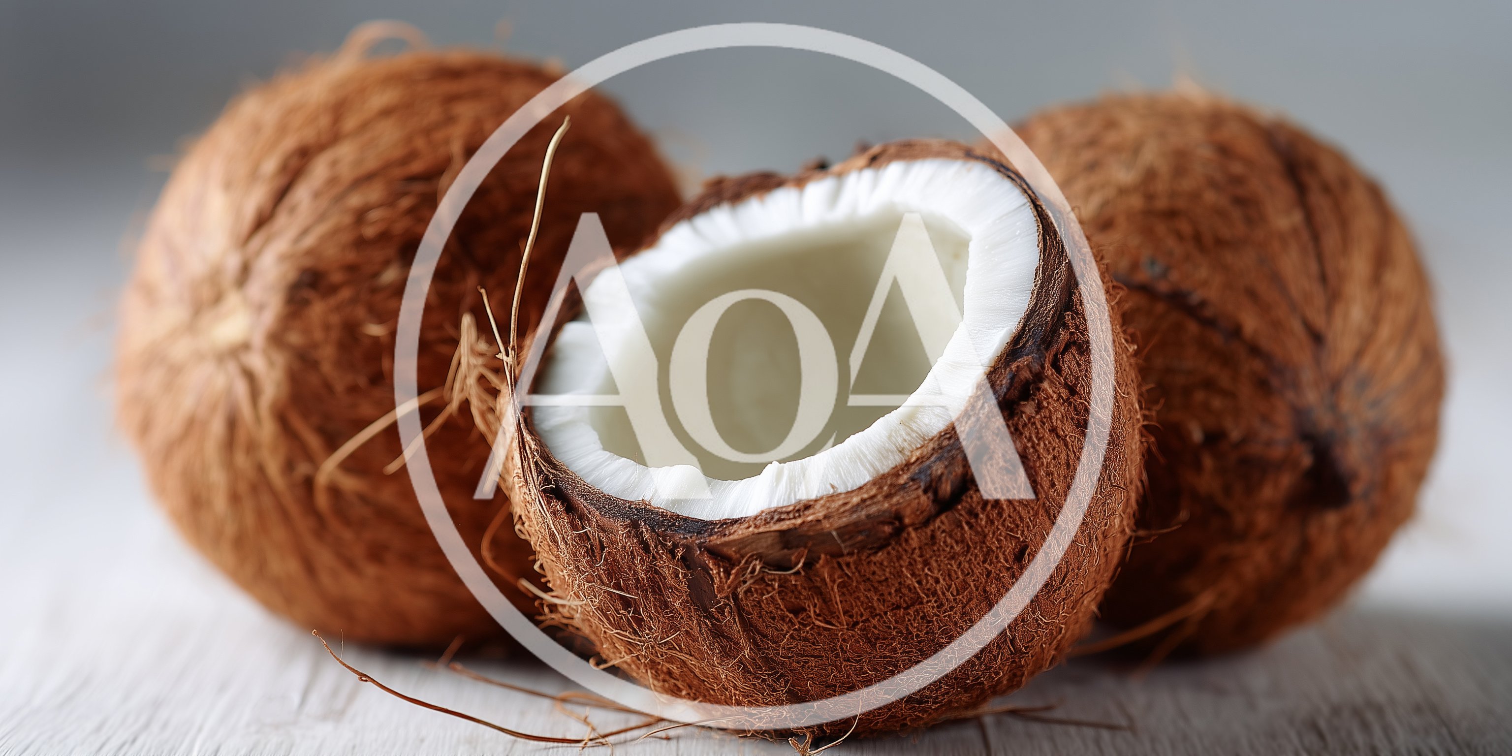 Three Whole And Halved Coconuts On White Surface